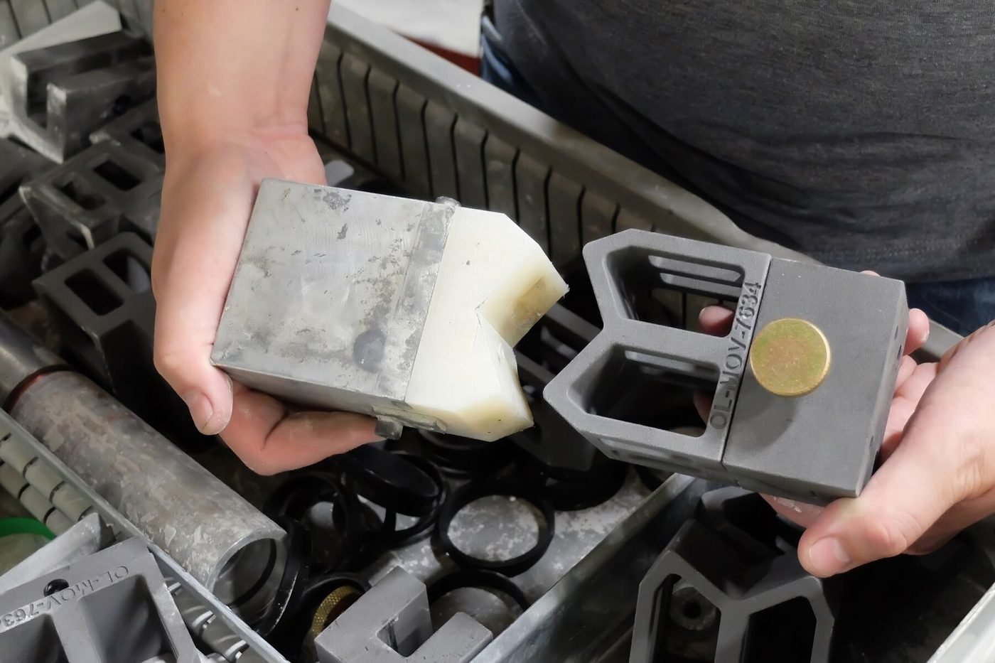 A reverse engineered replacement block beside the original metal part