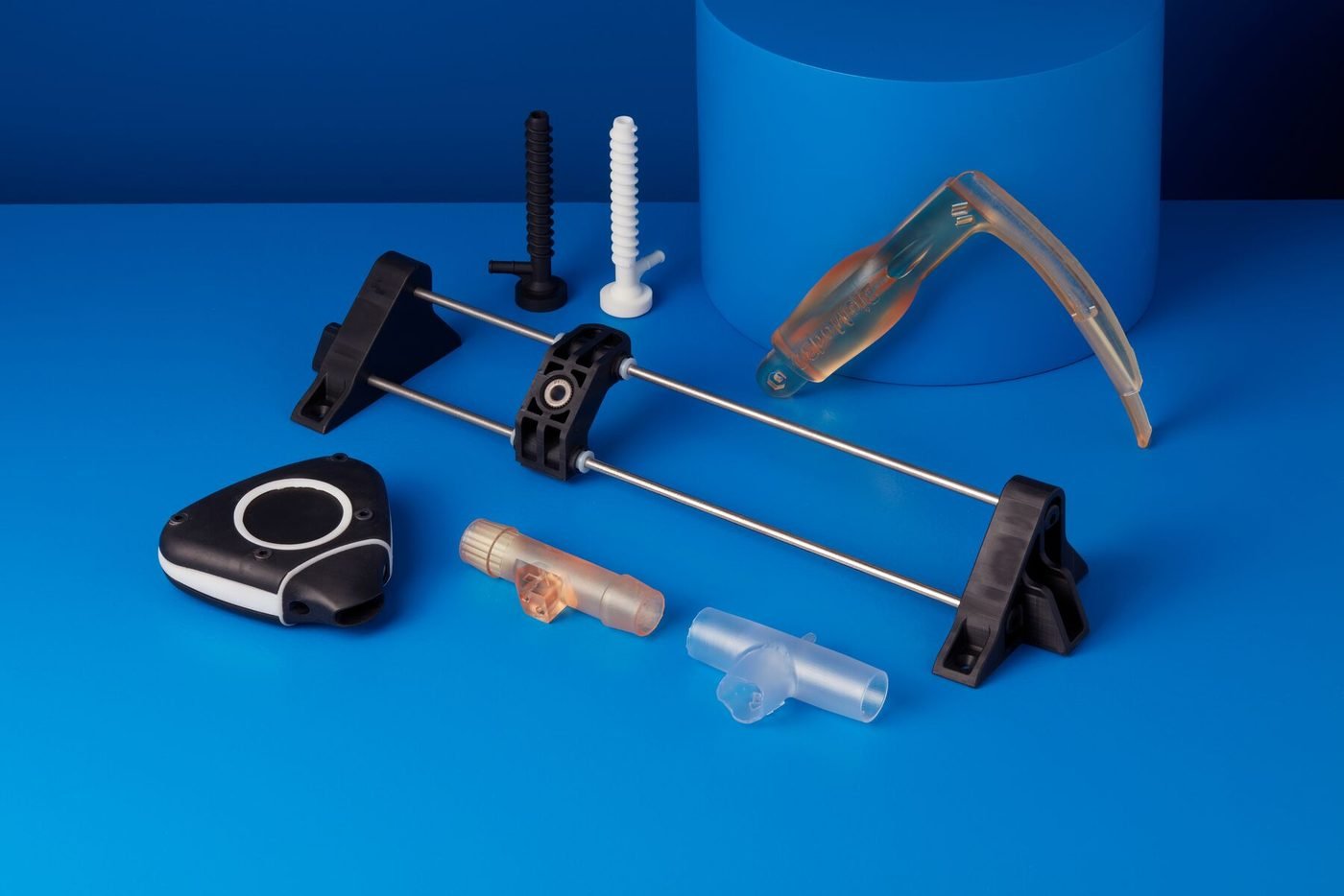 Printed dental and medical parts, including a surgical guide, on a blue background